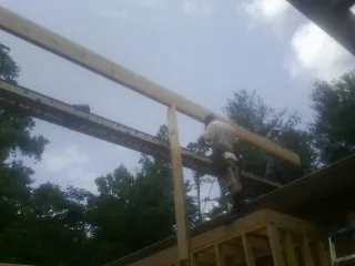 Carpenter setting a ridge beam over a new addition frame — Ice Dam Removal by Roofing Brothers in Amsterdam