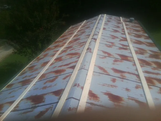 Rusted metal roof panels with new wood purlins before replacement — Storm Damage Roof Repair in Amsterdam by Roofing Brothers