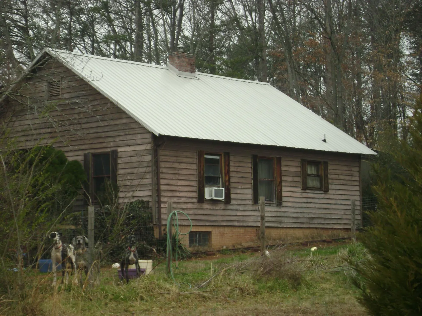 White metal roof on an old wood sided farmhouse, from a Metal Roof Installation job in Amsterdam